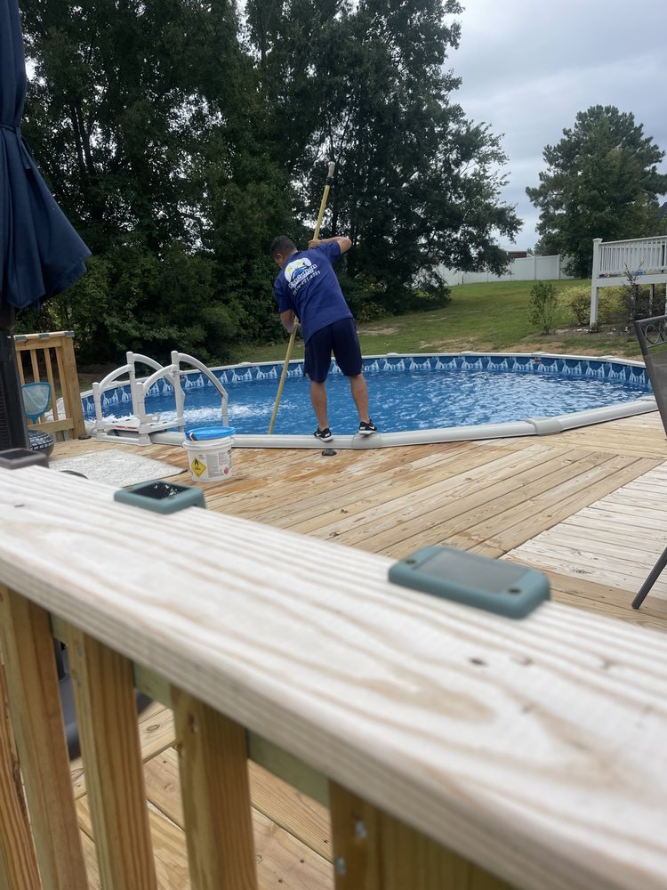Miguel brushing a pool during a maintenance visit